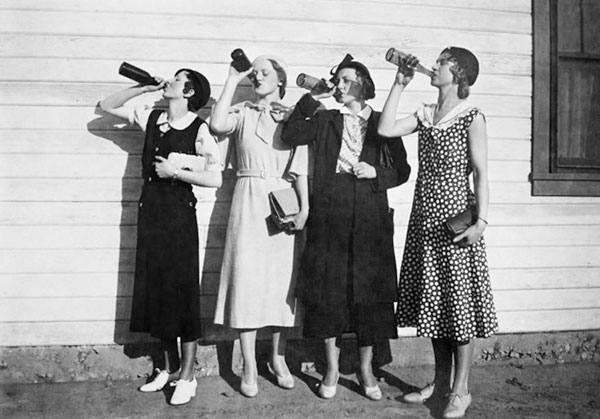 Four women drinking from bottles, 1920s